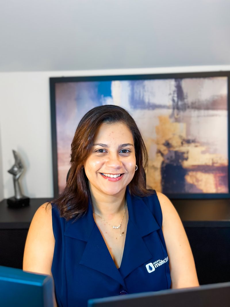 Colaboradora do administrativo sorrindo na sua mesa